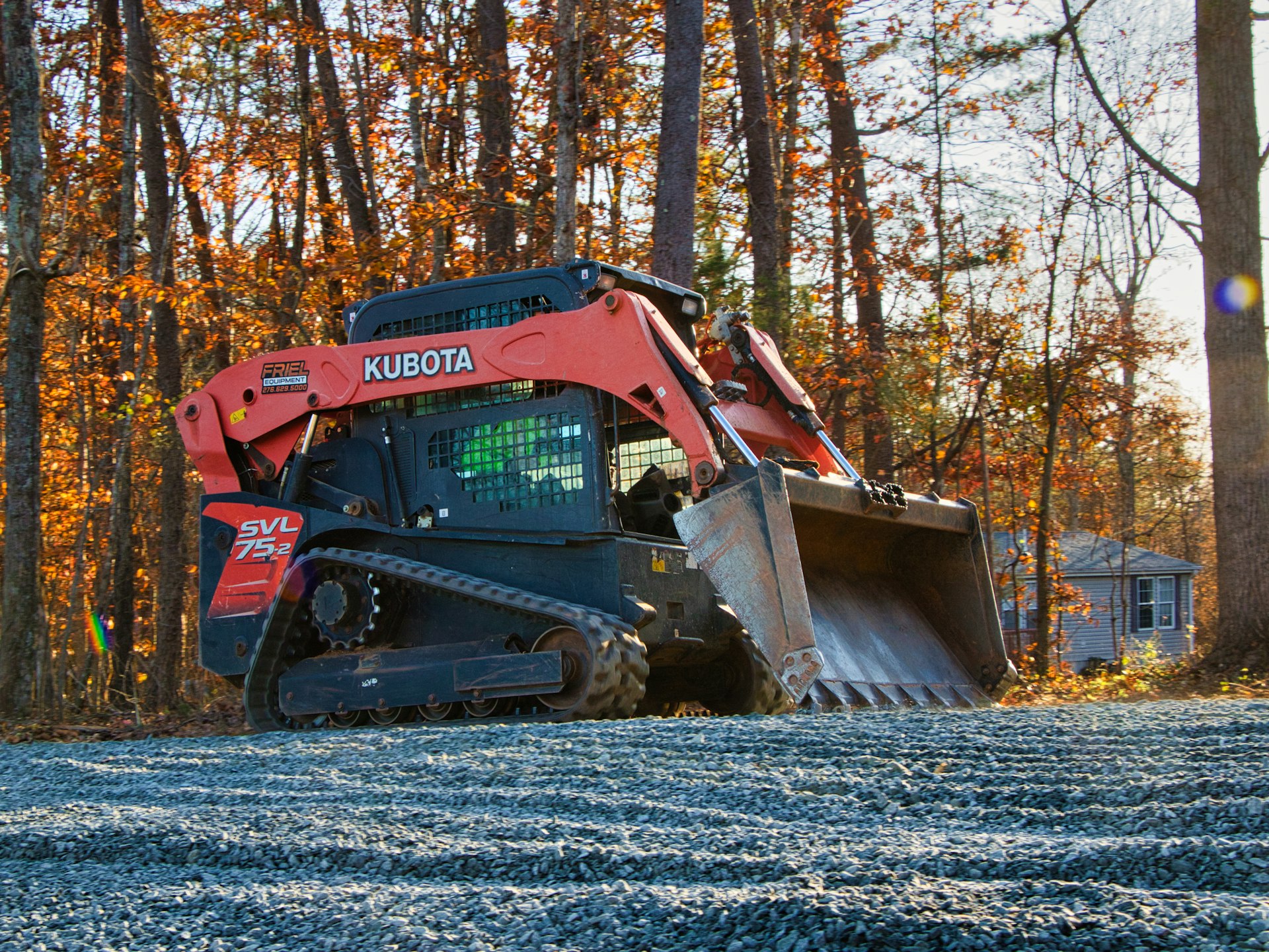 Orange kubota skid steer loader on gravel